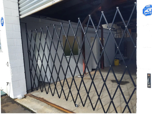 Black expandable barrier with adjustable scissor gate design for access control and safety management
