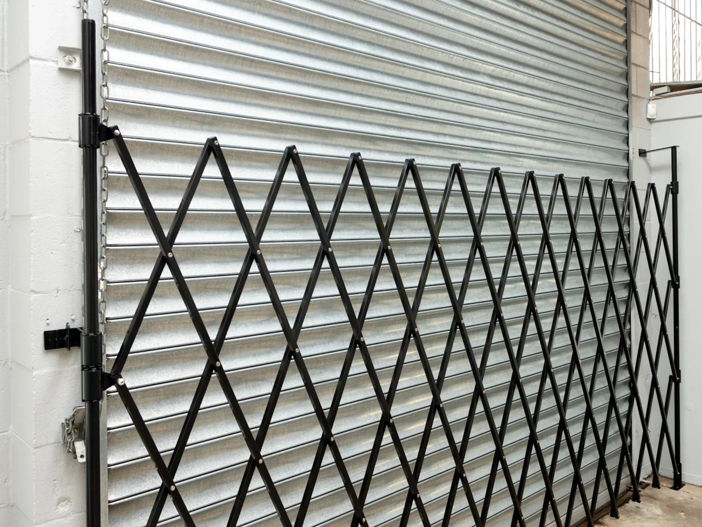 Black expandable barrier with adjustable scissor gate design for pedestrian access control and safety management