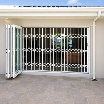 White aluminium retractable security gate installed across a wide residential doorway