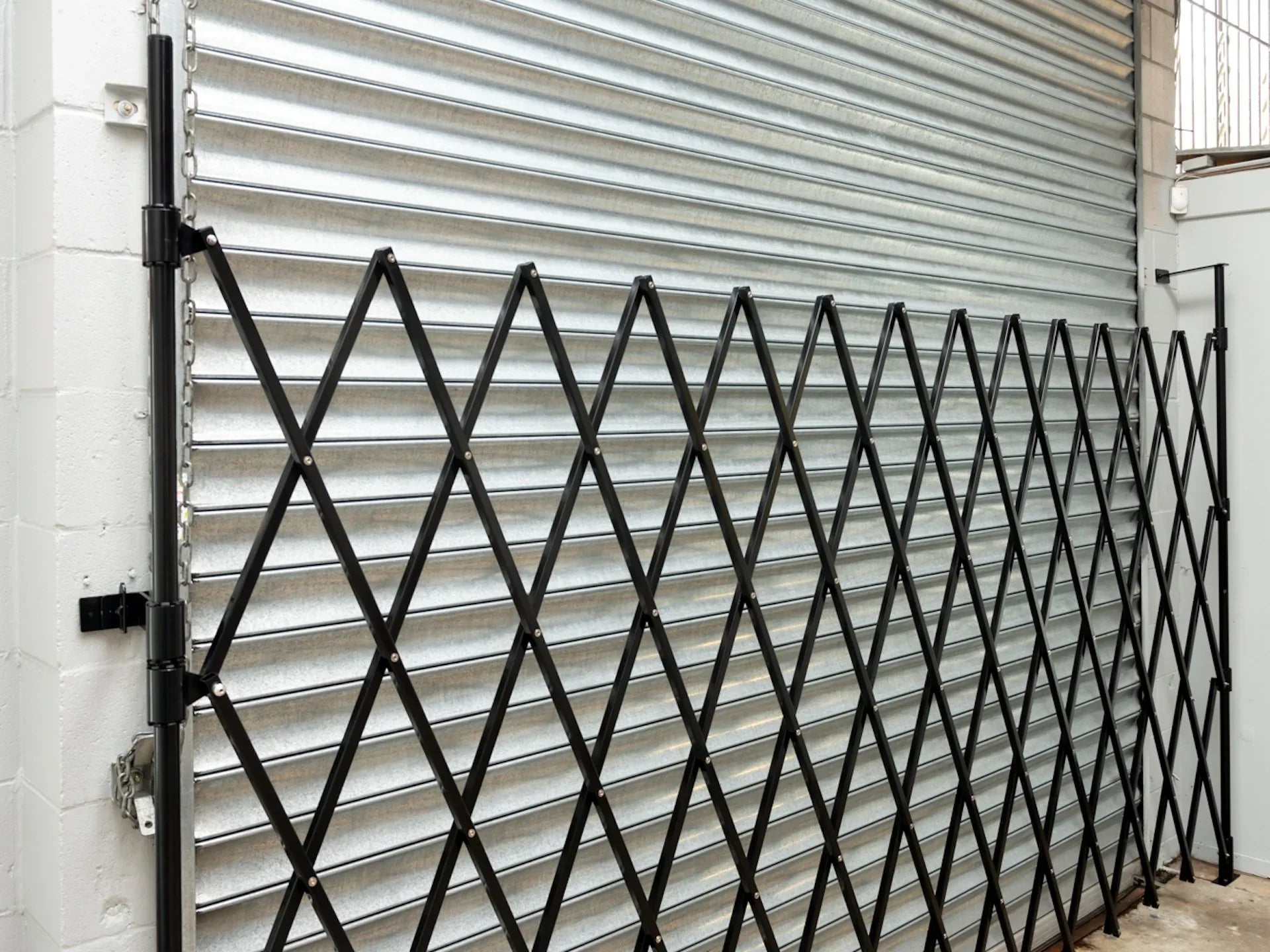 Black expandable barrier with adjustable scissor gate design for pedestrian access control and safety management